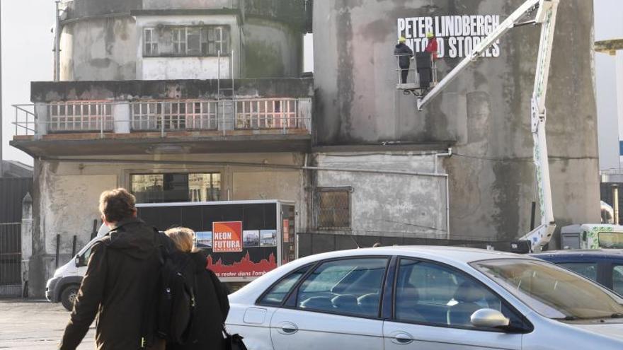 Operarios rotulan, ayer, uno de los antiguos silos de cemento en el puerto que anuncia la exposición.   | // CARLOS PARDELLAS