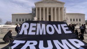 Un grupo de manifestantes despliega un cartel que pide sacar a Trump de la carrera electoral, este jueves frente al Tribunal Supremo.