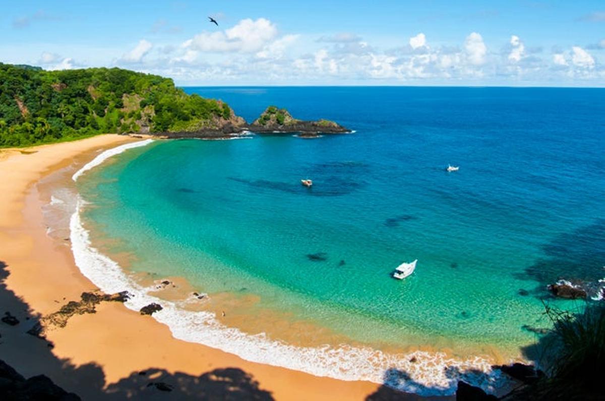 Baia Do Sancho, Fernando de Noronha, Brasil.  De difícil acceso por tierra, en la recoleta bahía do Sancho, uno se imagina estar en un refugio de piratas lleno de tesoros por descubrir, alejado del mundo y de una hermosura difícil de superar. Se halla en la pequeña isla de Fernando de Noronha, un paraíso natural protegido a poco más de una hora de vuelo desde Natal o Recife, los aeropuertos más cercanos desde la península brasileña. Su carácter recóndito y su naturaleza exuberante y caribeña sorprenden bastante, pues el archipiélago está en pleno Atlántico.