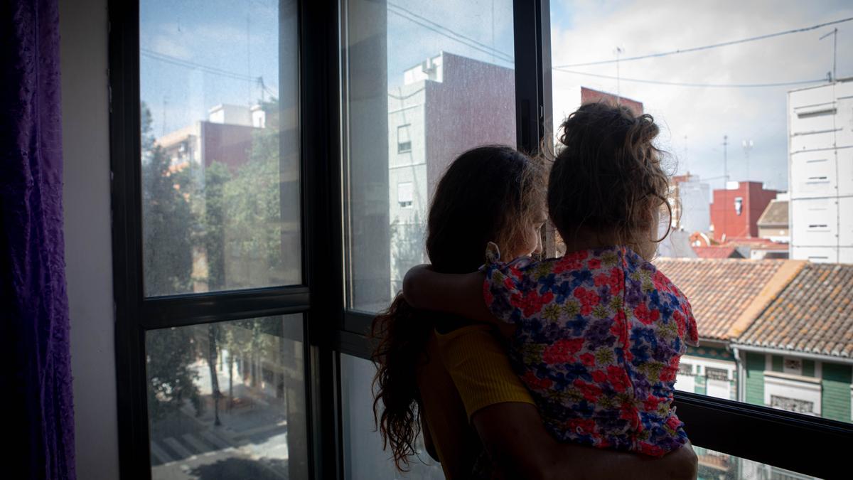 Tamara y su hija Irina miran por la ventana de su piso en el barrio del Cabanyal.