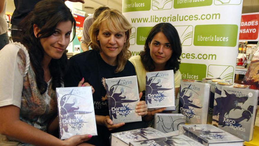 Tres lectoras muestran uno de los ejemplares de &#039;Danza de dragones&#039; en la Librería Luces.