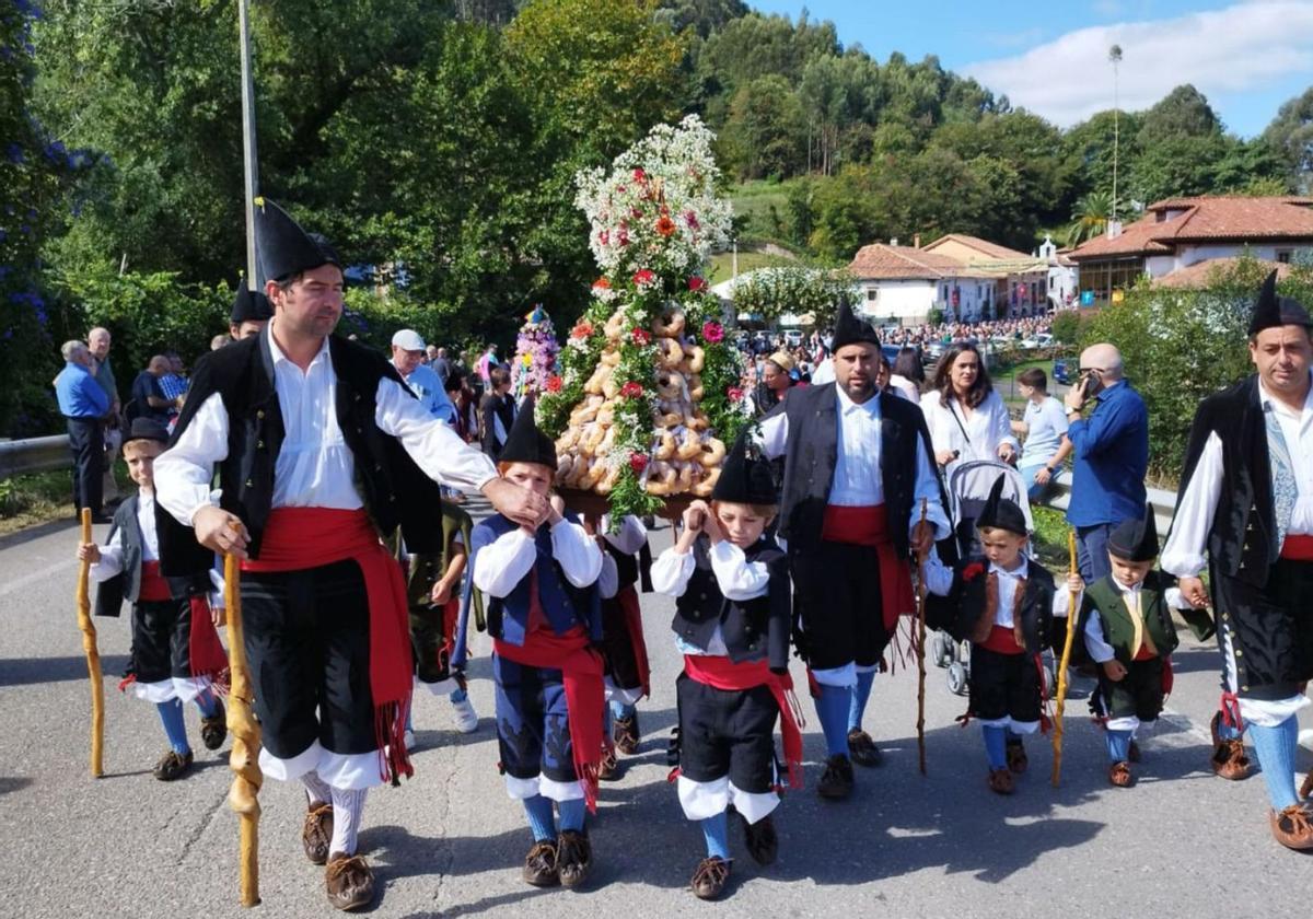 Niños y mayores ataviados con el traje de porruanos portan uno de los ramos. | J. Q.