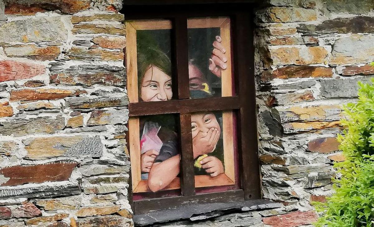 Cuadro de las tres niñas que parecen estar asomadas, en una casa del pueblo de Villaoril, en Ibias. | Foto de María del Roxo