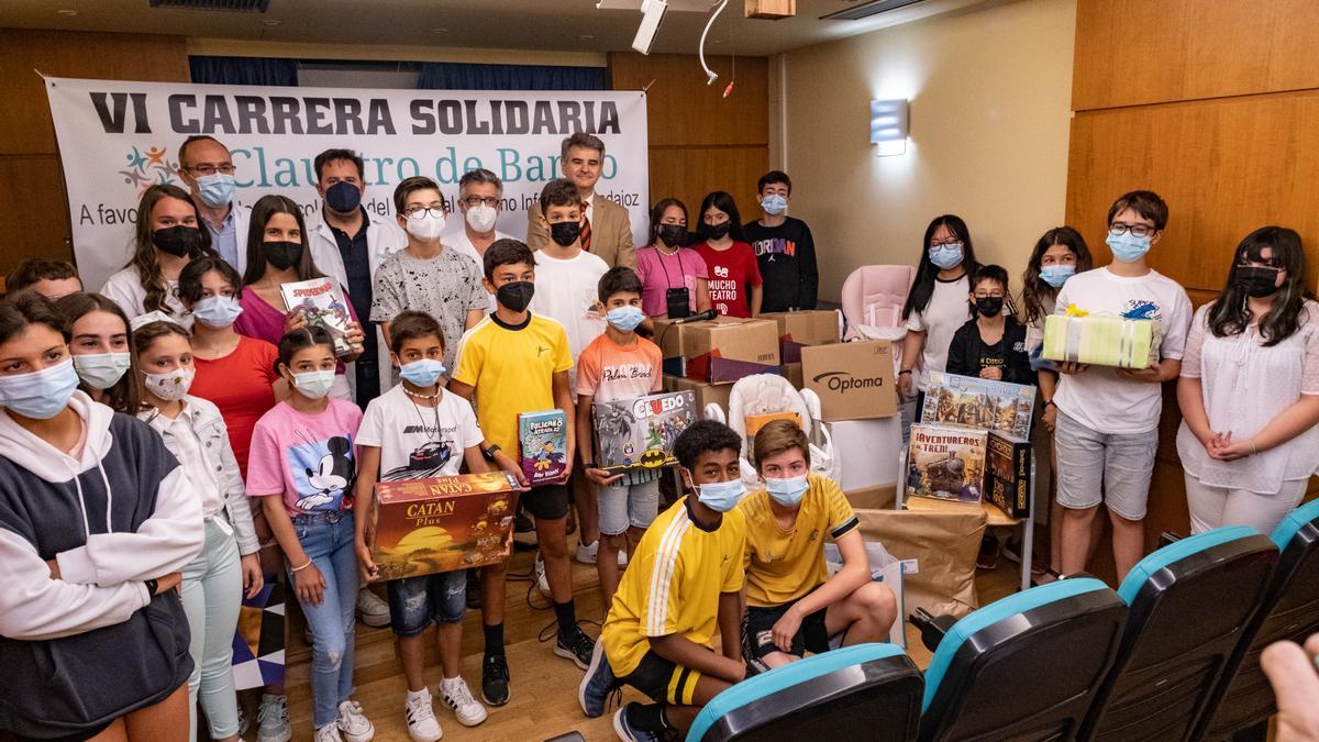 Escolares de San Roque, junto a responsables del SES, en la entrega de material para los niños de Oncología del hospital Materno Infantil de Badajoz.