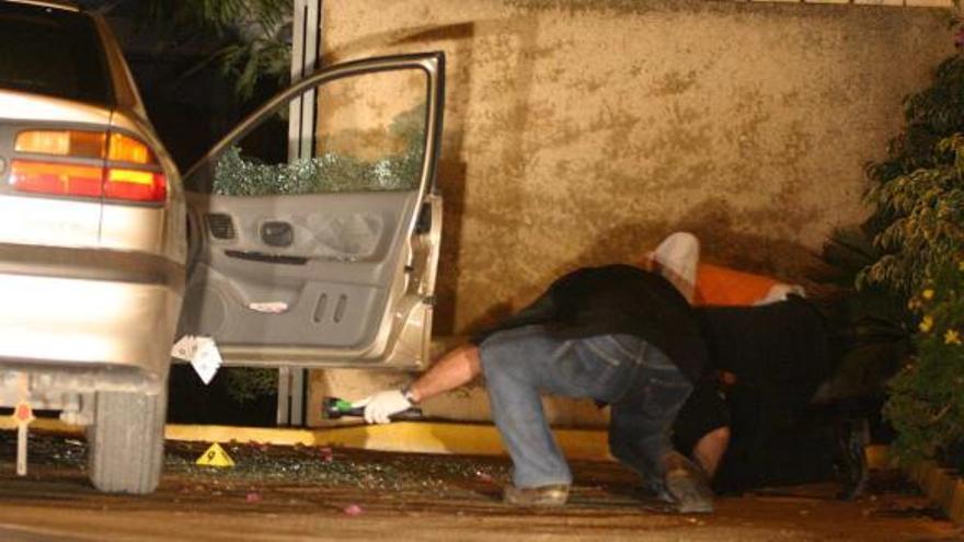 Imagen del coche donde fue tiroteado Ponsoda y la Guardia Civil inspeccionando el lugar.
