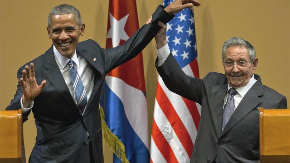 El presidente cubano, Raúl Castro, eleva el brazo del presidente Barack Obama en la conclusión de su conferencia de prensa conjunta en el Palacio de la Revolución.