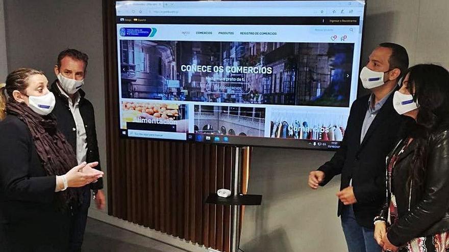 La concejala y algunos comerciantes presentan la web.