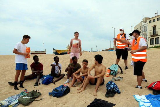 La platja de Blanes i els informadors explicant les mesures de seguretat