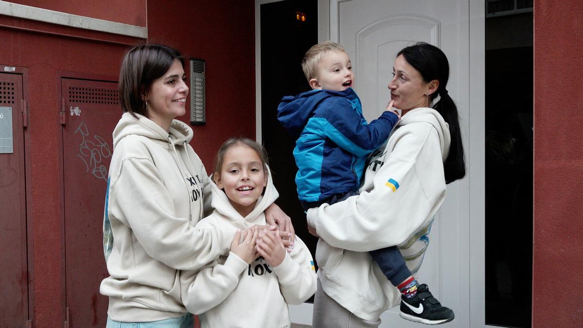 Alina Pavlivenenkova con su hija María, y Alesia Vinnik con su hijo Oskar, cuatro refugiados ucranianos frente a la puerta de su piso en El Vendrell (Baix Penedès).