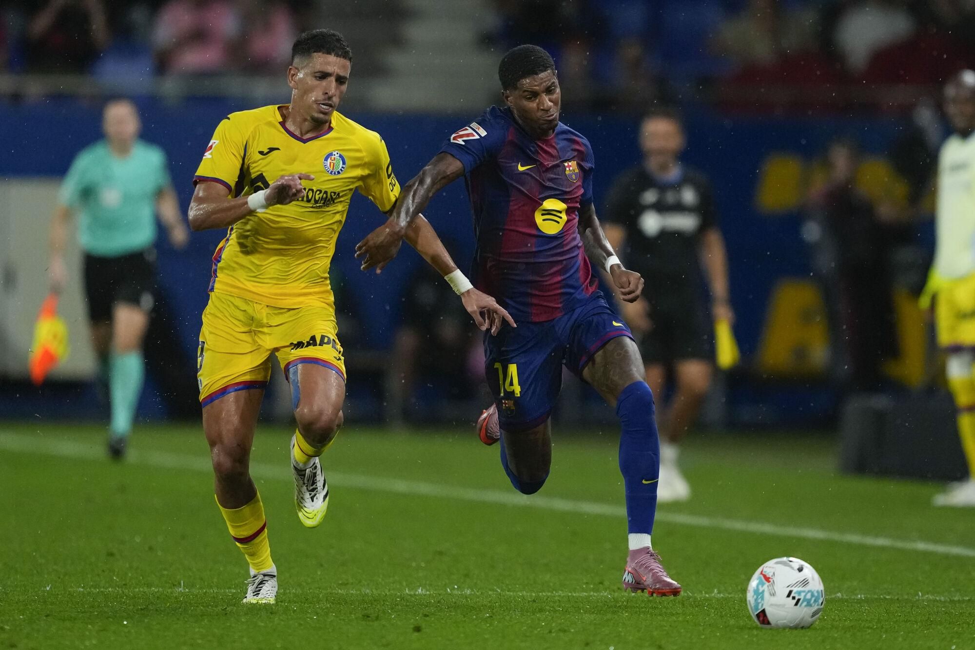 Barcelona striker Marcus Rashford (R) battles with Getafe's Abdelkabir Abqar during their LaLiga soccer match played at Johan Cruyff stadium in Barcelona, Spain on 21 September 2025. EFE/Alejandro Garcia