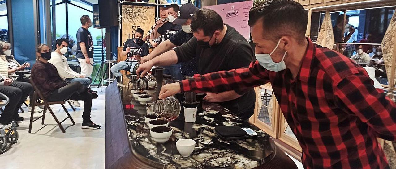 Tres de los competidores, en plena elaboración del café, ayer, en Salas. | S. Arias