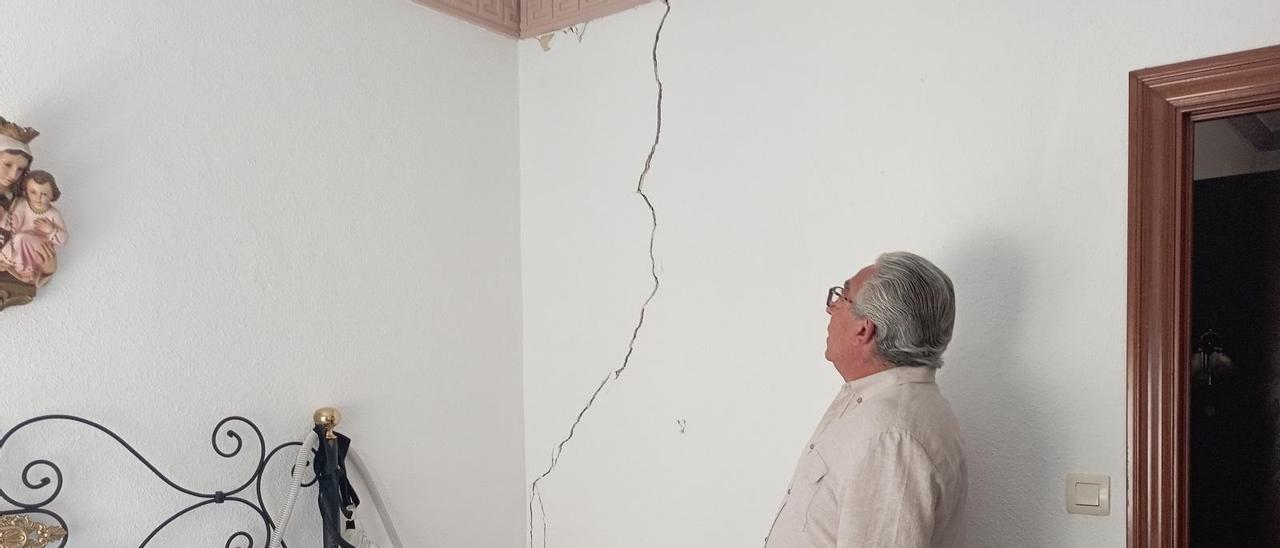 Un vecino muestra una de las grietas de su vivienda, que recorre la pared de su dormitorio.