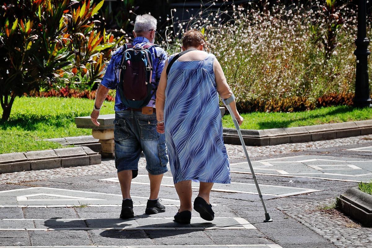 Una pareja de personas mayores pasea por Santa Cruz.