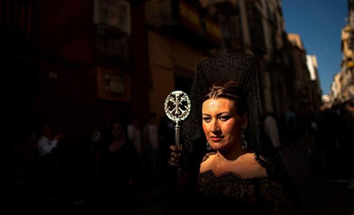 Llum. Una dona vestida amb la roba tradicional andalusa de Setmana Santa participa en una processó a Màlaga.