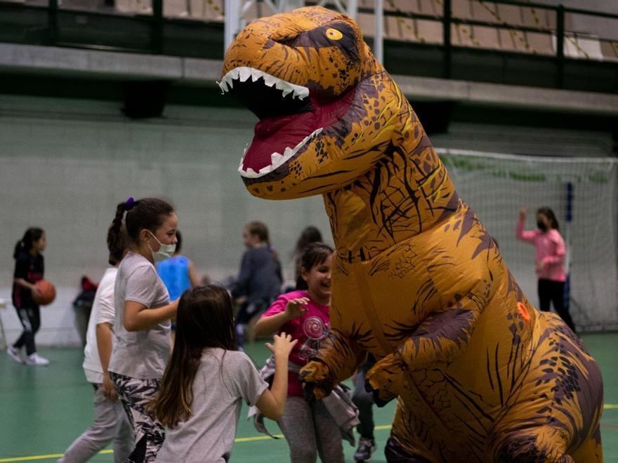 Un dinosaurio, rodeado de niñas del CB Zamora.