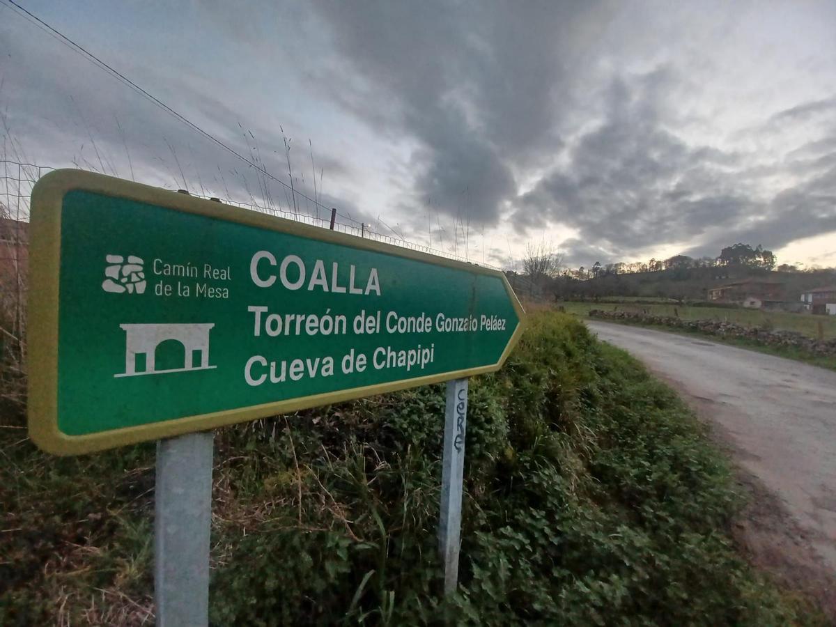 Indicador hacia Coalla donde se apunta que en el pueblo se localiza la cueva de Chapipi y el Torreón del Conde Coalla.