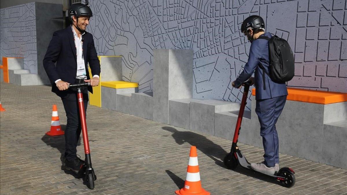 Dos personas prueban los patinetes eléctricos de Seat en la Smart City Expo de Barcelona.