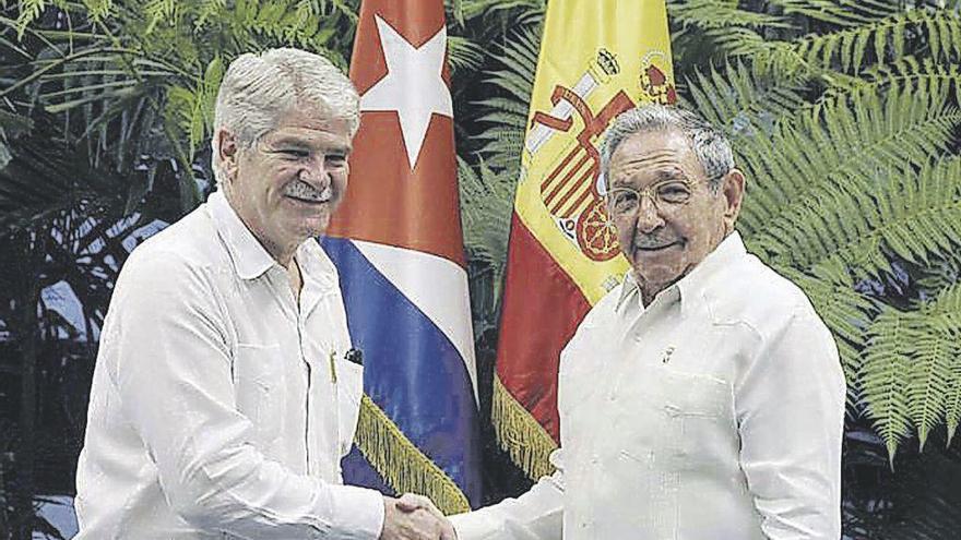 Raúl Castro, a la derecha, estrecha la mano del ministro de Exteriores español.