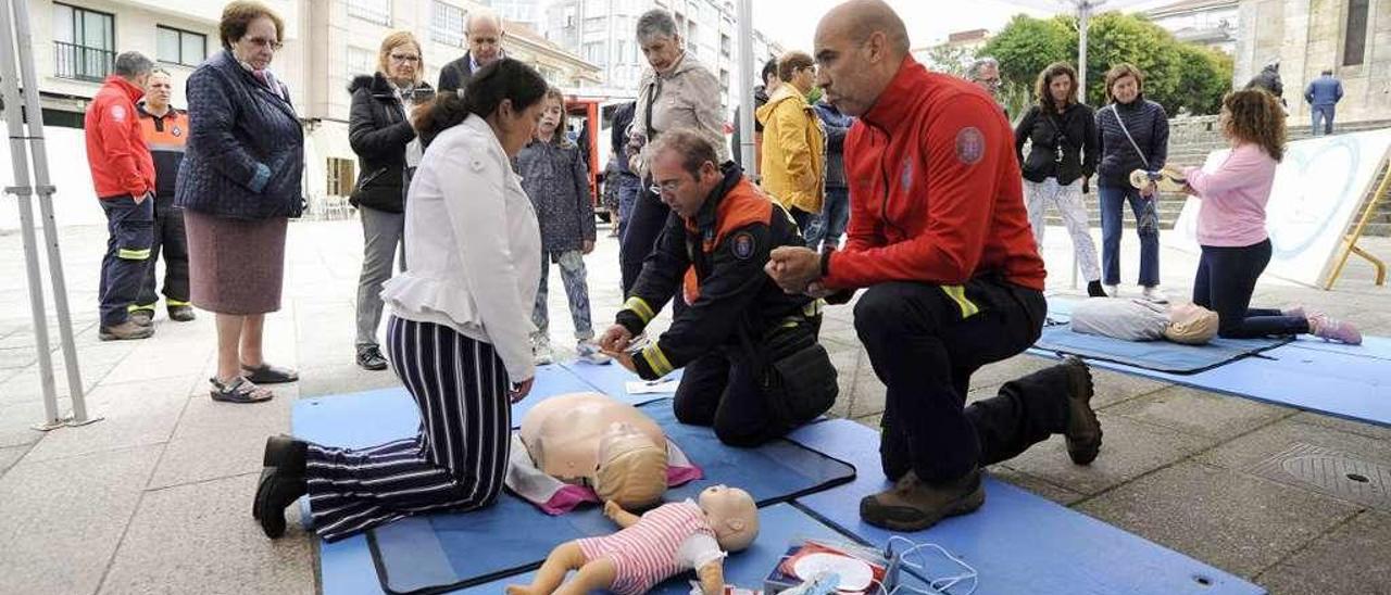 Miembros de Protección Civil y Eva Montoto explican a los asistentes las tareas de reanimación en la Praza da Igrexa. // Bernabé/Javier Lalín