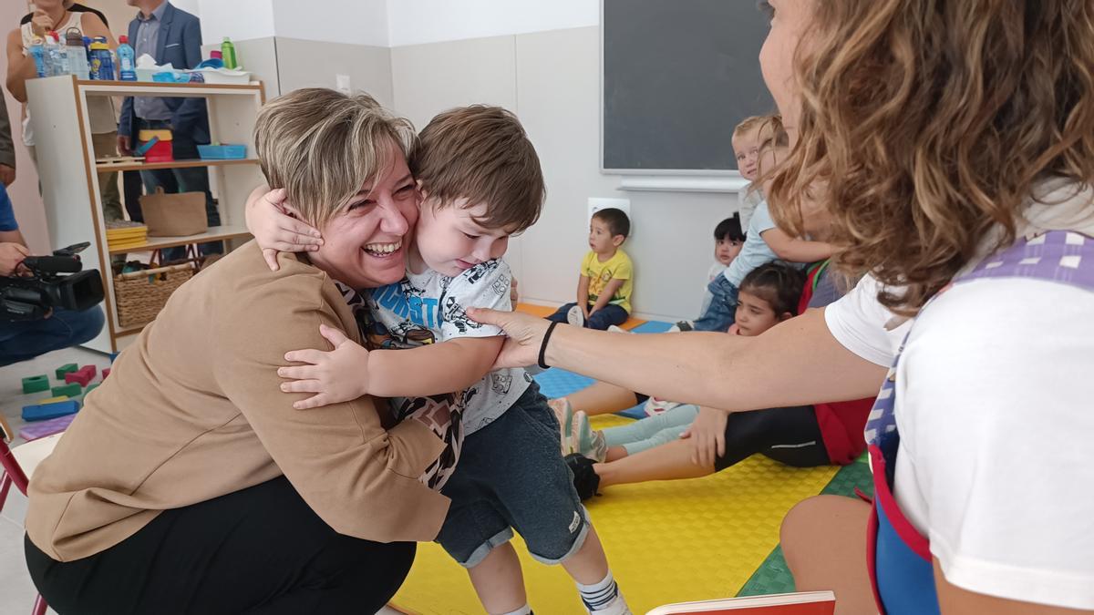 Un niño abrazándose a la consellera de Educación durante su visita al CEIP Doctor Calatayud de Aspe.