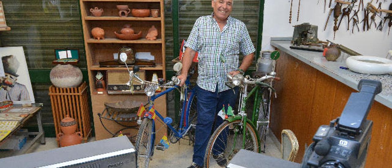 Antonio Santana en su museo mientras agarra sus bicicletas, los dos objetos que más estima de entre su colección.