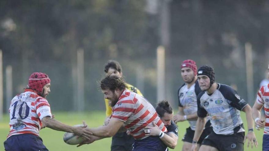 Los jugadores del CRAT intentan recuperar el oval ante el Universidad de Vigo.