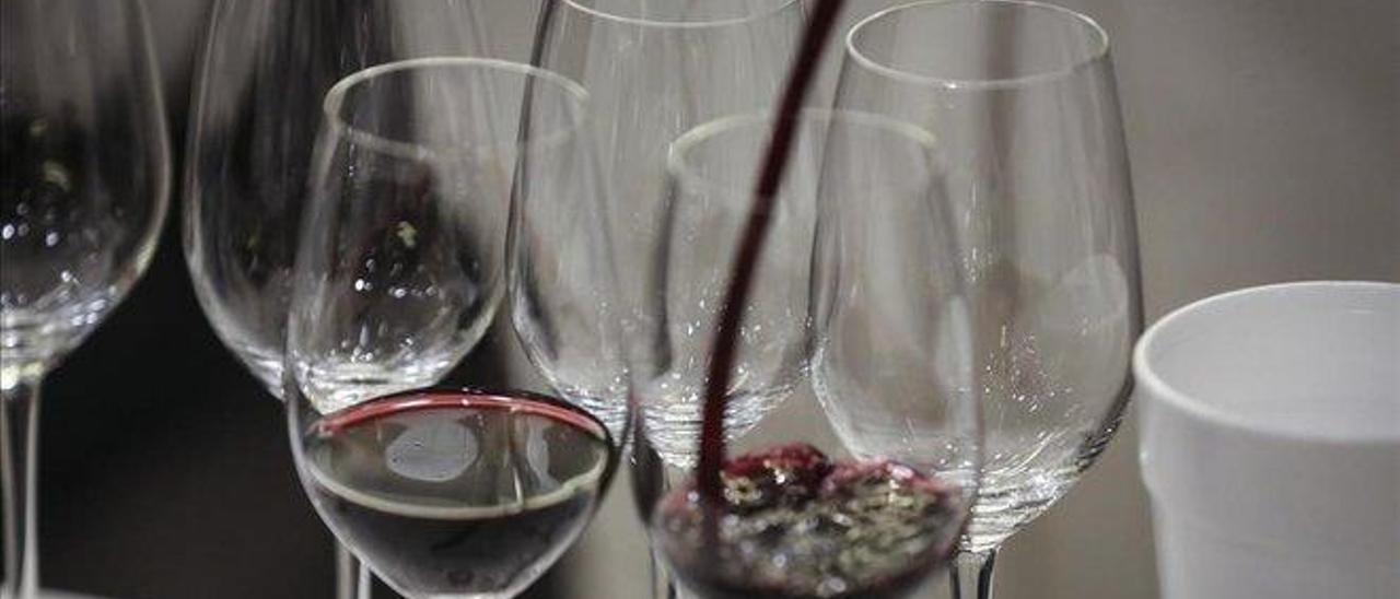 Imagen de archivo de una persona sirviendo copas de vino.