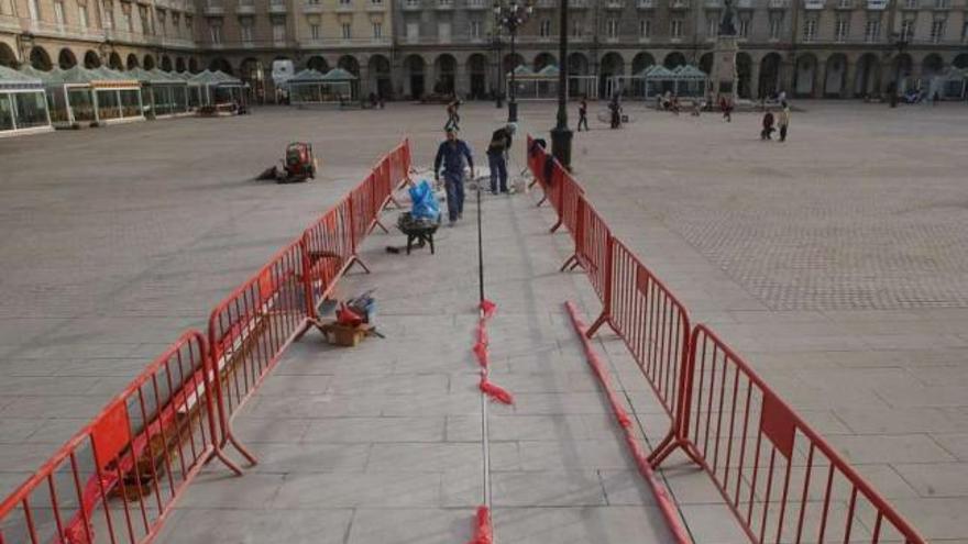 Dos operarios instalan los primeros metros de la barra de acero que marca el meridiano. / víctor echave