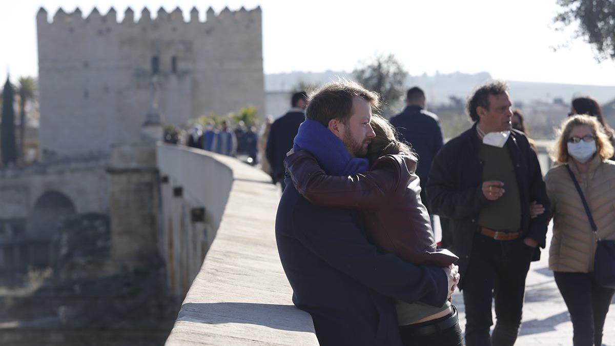 Una mujer y un hombre se abrazan en el Puente Romano.