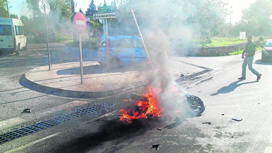 Un hombre intenta apagar las llamas que destruyeron la moto con un extintor; al fondo, la primera ambulancia que llegó.