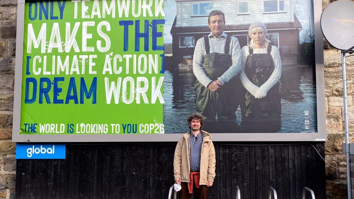 Pau de Vílchez posa ante un cartel alusivo a la lucha contra el cambio climático en Glasgow.