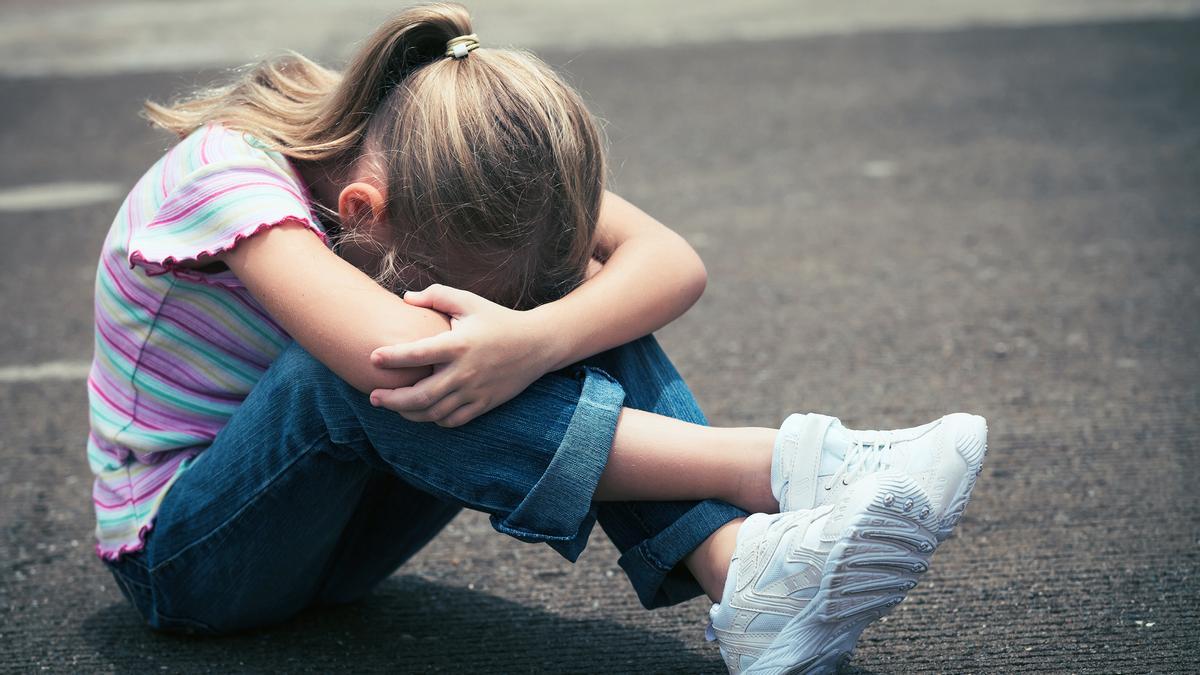 Tristeza , niña triste sentada en el suelo