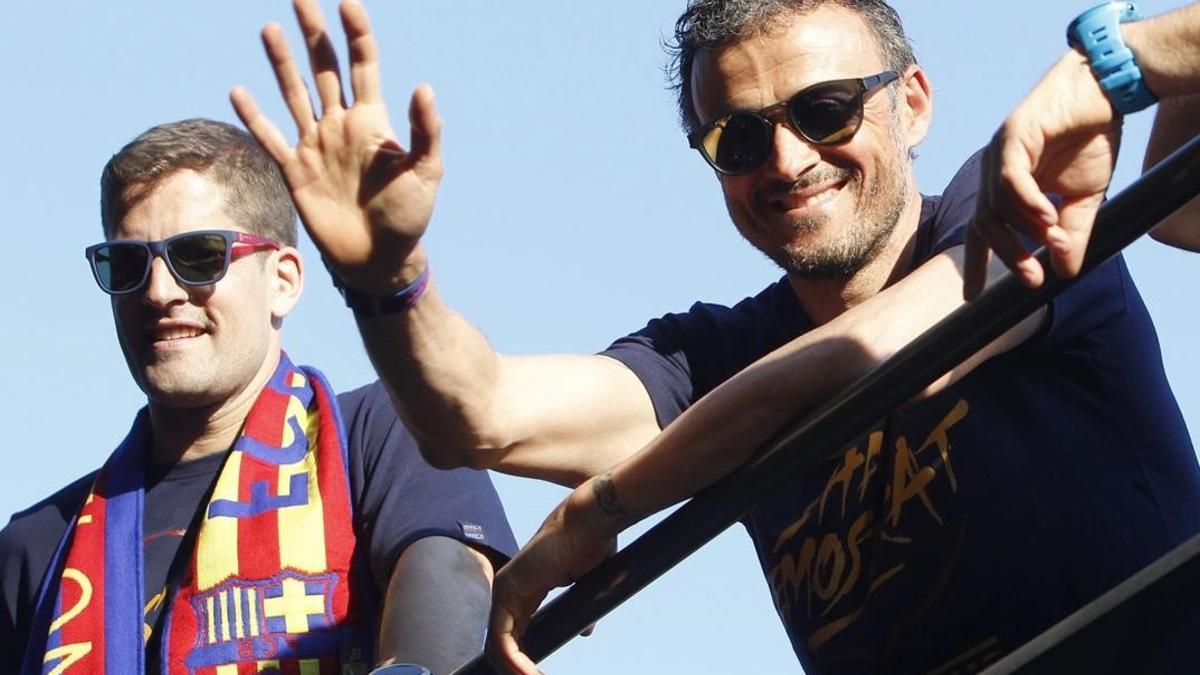 Luis Enrique saluda a los aficionados del Barça al lado de Robert Moreno, uno de sus ayudantes.