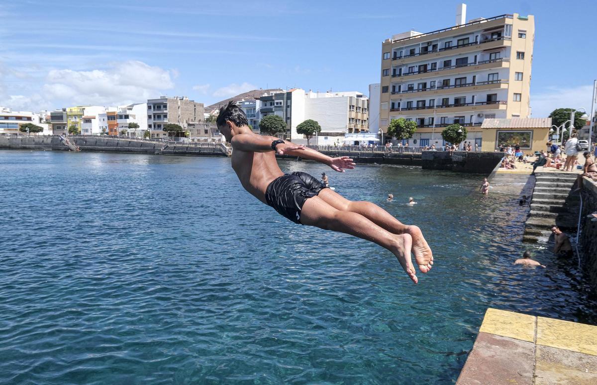 Un joven disfruta del domingo mientras se tira por el muelle de Arinaga