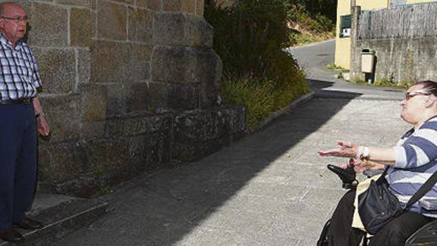 La vecina ante la iglesia y el cura, en la puerta de la sacristía.