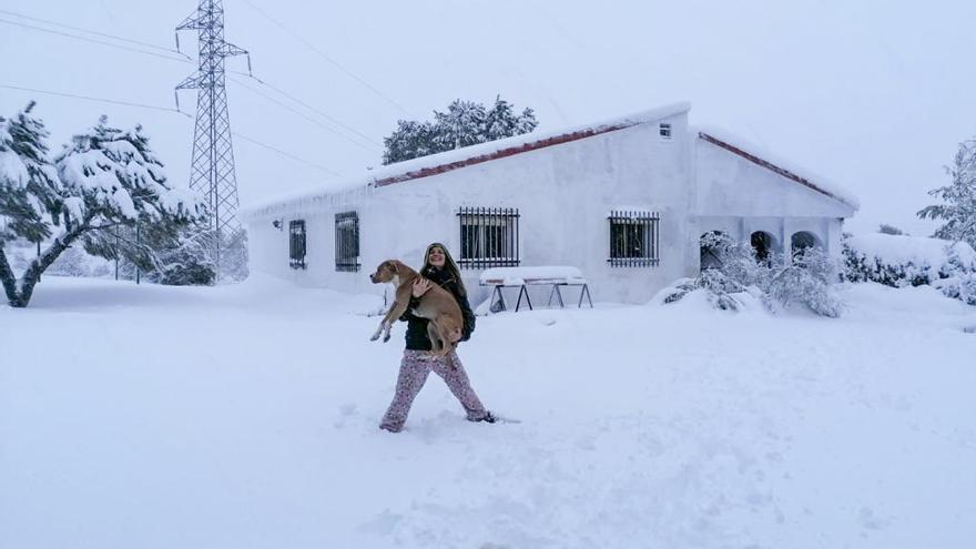 Ana, vecina de Benidorm, junto a su perro ante la casa en la Serra Mariola en la que siguen aislados.