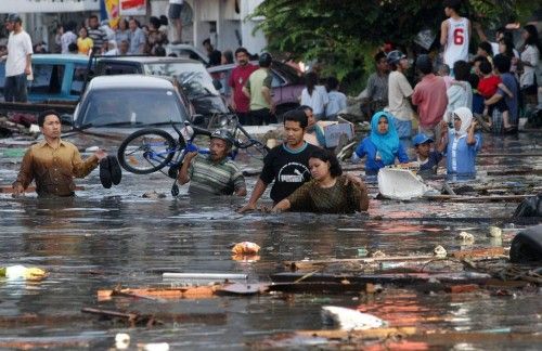 ACEHNESES WADE THROUGH FLOODED STREET