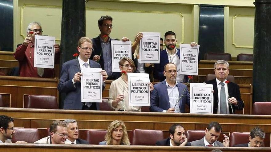 Los diputados del PDeCAT exhiben pancartas y claveles en apoyo a Sànchez y Cuixart, ayer durante el pleno del Congreso. // Efe