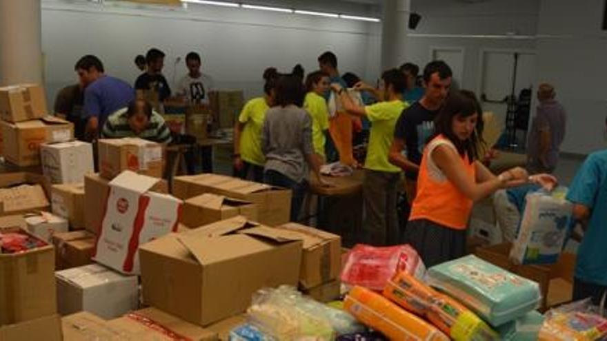 Voluntaris reben, classifiquen i empaqueten el material al centre cívic de Berga