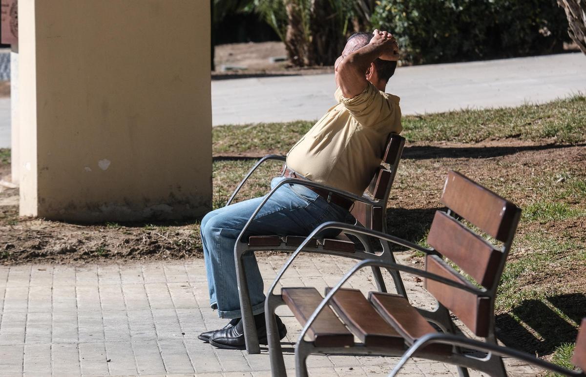 Un pensionista toma el sol en un banco en Elche