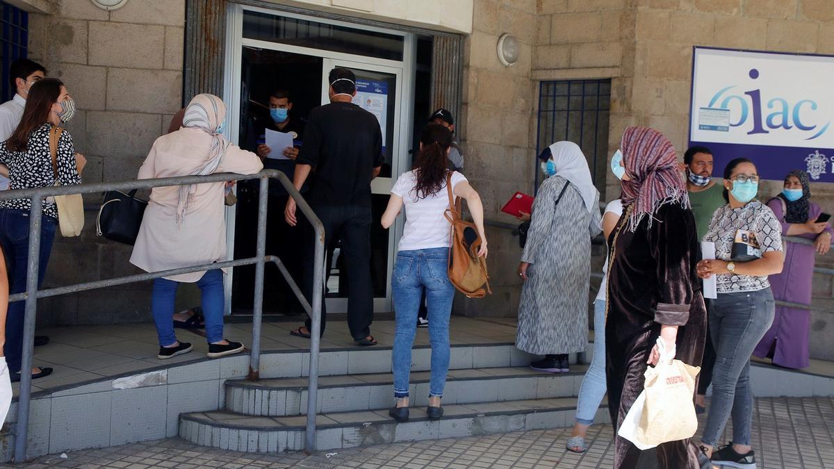 Varias personas esperan su turno para solicitar los documentos con los que pedir el Ingreso Mínimo Vital (IMV), en Melilla, en una fotografía de archivo. EFE/Francisco G. Guerrero