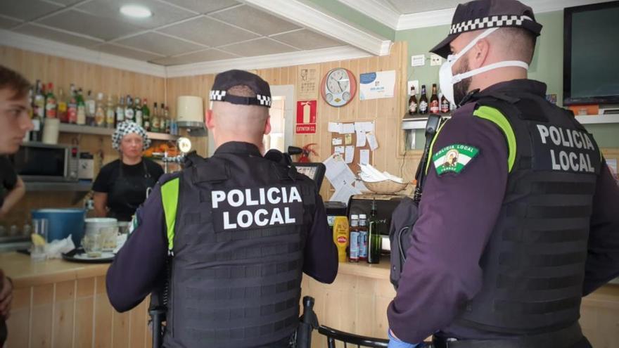 Agentes de la policía local de Torrox cerrando bares en el municipio.