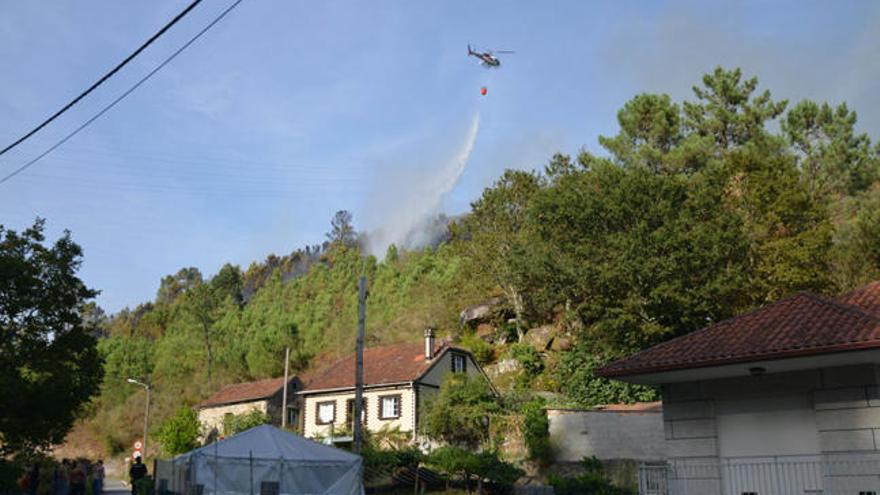 Un helicóptero, sofocando el incendio iniciado esta tarde en Pontesampaio. // G. Santos