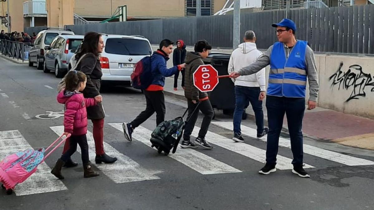 Uno de los voluntarios de las patrullas escolares regula el tráfico en uno de los accesos al colegio Pintor Gimeno Barón.