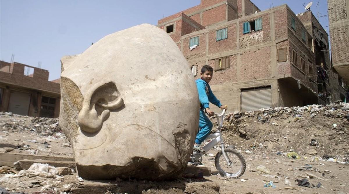 ealos37617847 a boy rides his his bicycle past a recently discovered statu170310132531