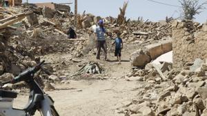 Varias personas caminan entre los escombros en la aldea de Tafagajt, en Marruecos, cerca del epicentro del devastador terremoto.