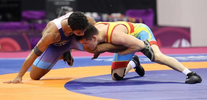 Meirzhan Ashirov de Kazajstán (amarillo) lucha con Naveen de la India (azul) en el combate por la medalla de bronce en la categoría masculina de 70 kg en los Campeonatos Asiáticos de Lucha Libre de 2020 en Nueva Delhi, India.