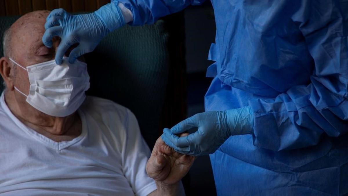 Un anciano es atendido por el personal médico de un CAP en el Raval (Barcelona).