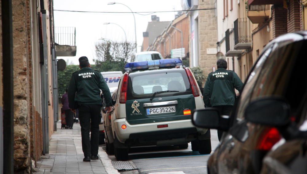 Dos agents de la Guàrdia Civil pujant al vehicle policial durant l'operatiu al carrer Pujades de Figueres