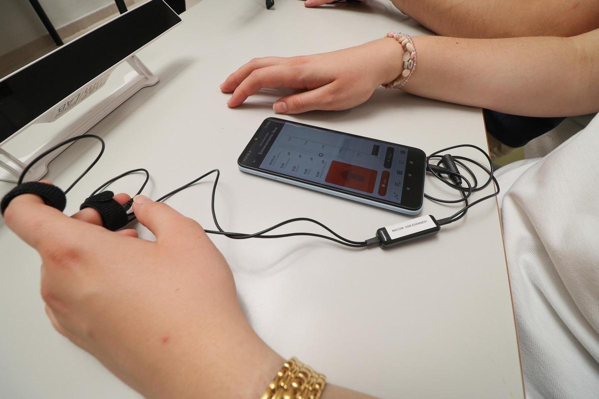 Dispositivos que miden la actividad electrodérmica mediante la sudoración de los dedos registrando la intensidad emocional del estudiante.